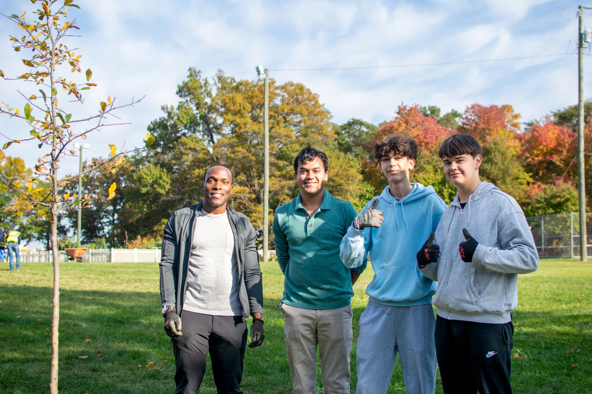 Group of young men stand next to a tree